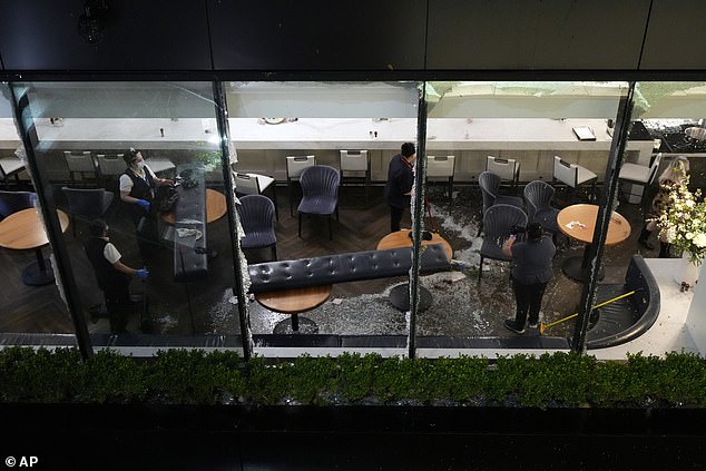 Workers clean up damage inside a downtown restaurant after a strong storm passed through Houston