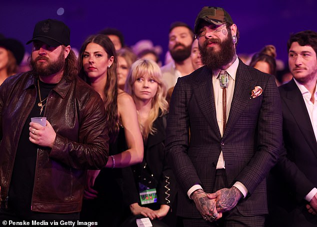 During the rest of the ceremony he chose to wear a dark checked suit with a light-collared shirt with a bolo tie.