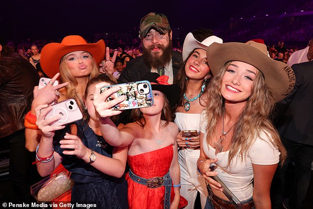 During the ceremony, Malone joined some young fans to take some selfies.