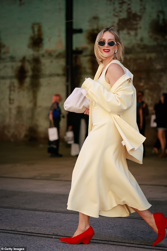 She completed her look with bright red heels and accessorized them with chic sunglasses, gold earrings and a touch of bold scarlet lipstick.