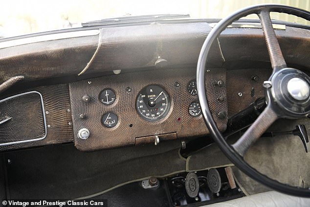 The maroon and gold 1953 Rolls Royce Silver Wraith Hooper Sedanca is complete with chrome trim and trimmed inside with reptile skin on the dashboard.