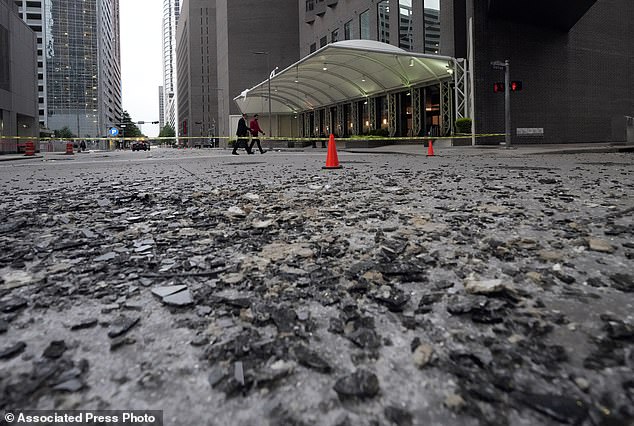 Broken glass covers a downtown street after a severe thunderstorm on Friday, May 17, 2024, in Houston