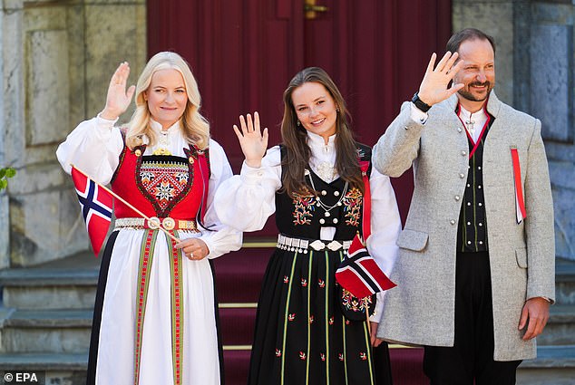 Princess Mette-Marit wowed in a traditional red and white ensemble as she waved a Norwegian flag from the steps of her residence.