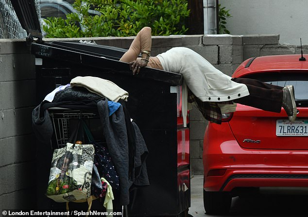 In one of the photos, Loni was seen throwing herself into a dumpster while the outline of her bra peeked through her thin blouse.