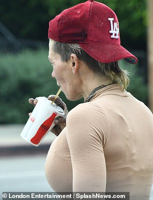 The former model wore a nude top, brown pants, a pair of brown Converse and a red baseball cap.