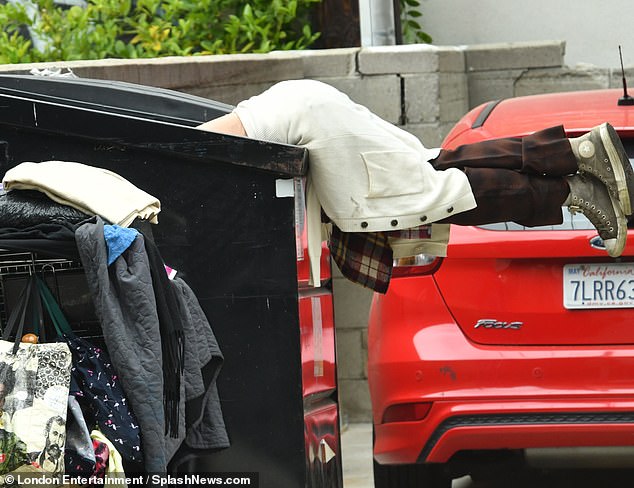 He tied a flannel shirt and a white jacket around his waist before pulling a red baseball cap over his short locks.