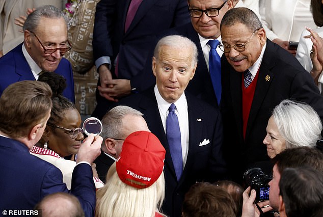 Biden reacts as he looks at U.S. Rep. Marjorie Taylor Greene during the State of the Union March as he walks to Congress.