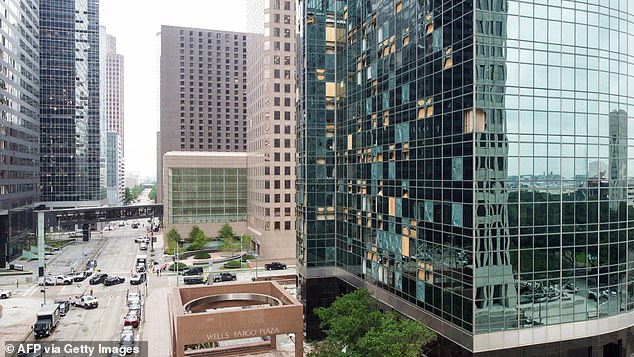 Louisiana Street is closed to traffic as workers clear debris from broken windows of the Wells Fargo Plaza building in Houston