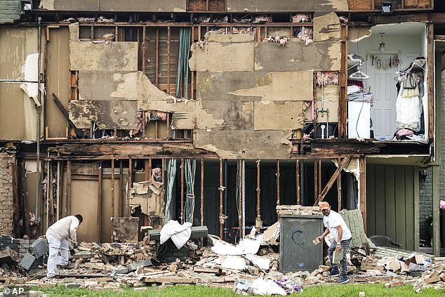 Crews work to clear debris after a wall falls.