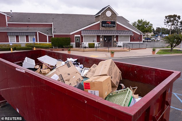 A trash container is displayed in front of a closed Red Lobster restaurant whose entire contents are up for auction in San Diego, California.