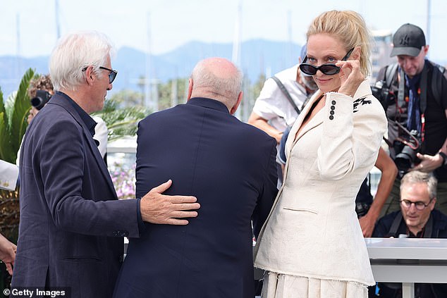 Richard put a supportive hand on Paul's back as he bowed and Uma stepped away from the men to lower her sunglasses once more and gaze charmingly at the attendees.