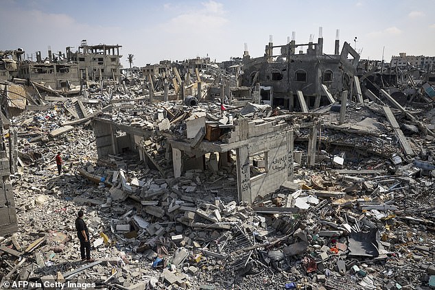 Greenberg Call, 26, is the first Jewish political official to publicly resign over US support for 'Israel's genocide' (Pictured: People inspect damage among the rubble of buildings destroyed during the Israeli bombing in Khan Yunis)