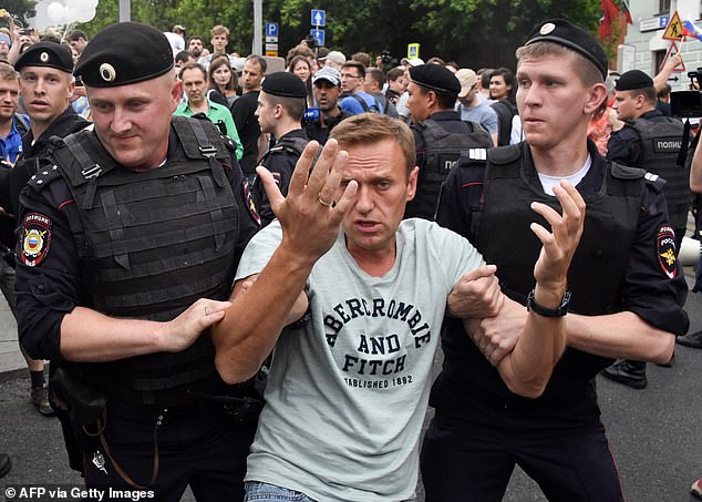 Opposition leader Alexei Navalny is detained by Russian police officers during a march to protest alleged impunity by law enforcement in central Moscow on June 12, 2019.