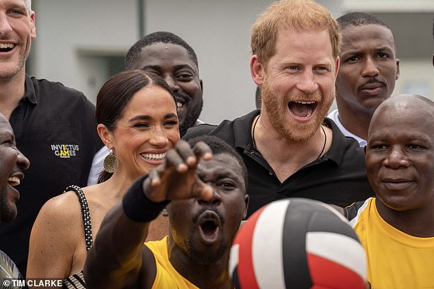 Harry listens as he urges the Invictus athletes, while Meghan looks delighted by his side.