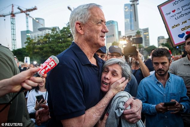 Gantz hugs a woman as he walks to meet the hostages' families. Gantz said: 