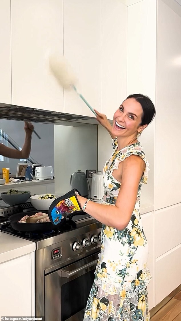 After pretending to attend the commencement speech, Laura excitedly took off her graduation suit to reveal a 50s-style floral dress underneath, before grabbing a duster and frying pan.