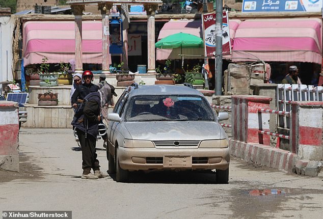 Four people were arrested following the shooting in the city of Bamyan, central Afghanistan (pictured: a member of the Afghan security forces checks a vehicle after the shooting)