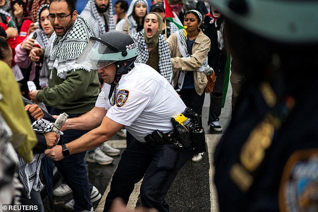 An NYPD officer grabs a pro-Palestinian protester during today's protest