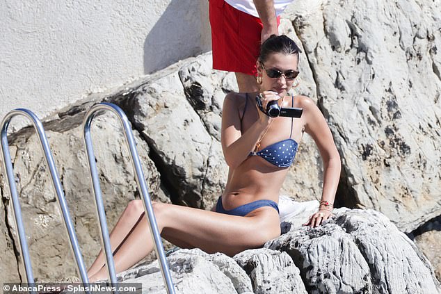 The star showed off her toned abs and lithe legs as she posed on rocks and used a video camera to capture moments of the day in the sun.