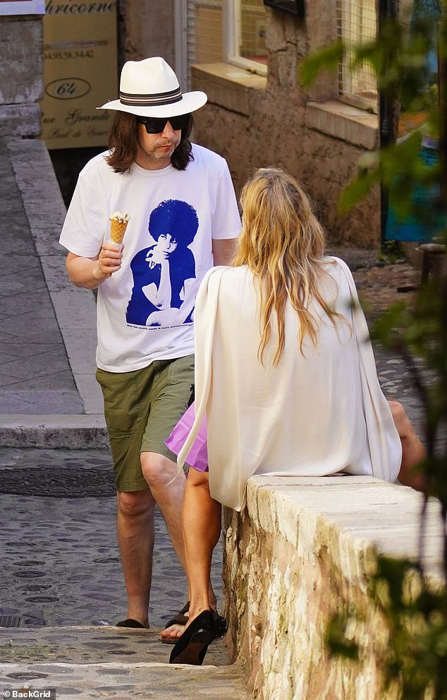 Meanwhile, Primal Scream rocker Bobby, 52, wore a white T-shirt and khaki shorts while hanging out with his pal.