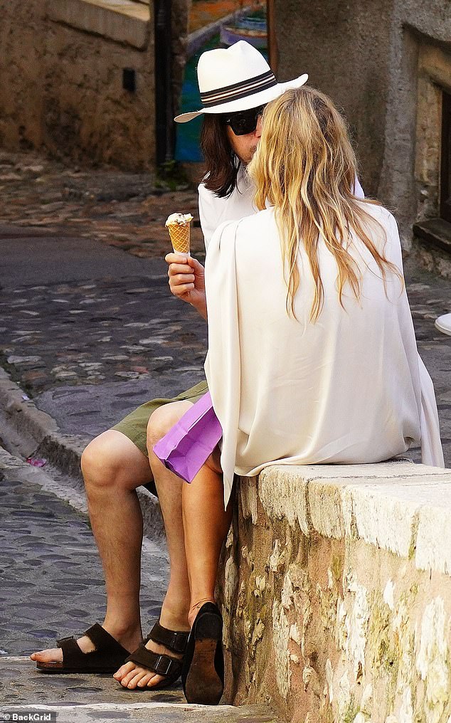 They sat on a wall and chatted while eating their ice creams.