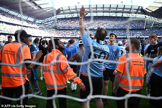 City fans on the field after the final whistle.