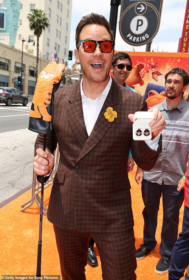 The actor had fun posing with a couple of accessories, including Garfield's golf club cover, sunglasses, and earrings shaped like Christmas tree ornaments.