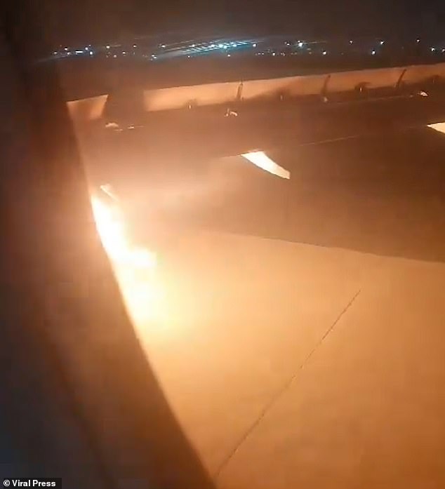 Once the plane returns to the runway, a public address system tells passengers to remain seated as the fire appears to get brighter.