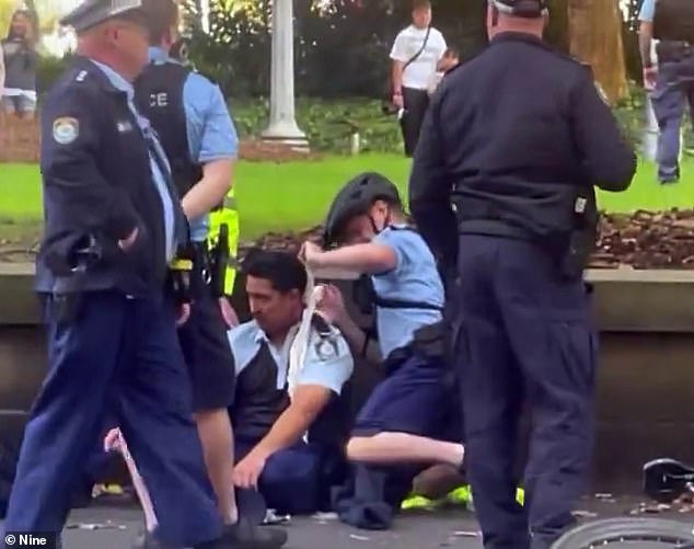 Pictured: Constable Poa receives treatment in Hyde Park on Sunday after he was allegedly stabbed.