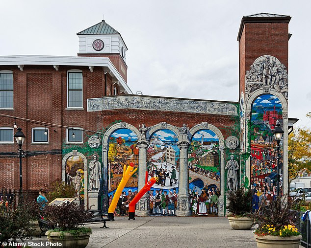 A brightly painted mural on the wall of an old brick mill on the riverbank in Ipswich