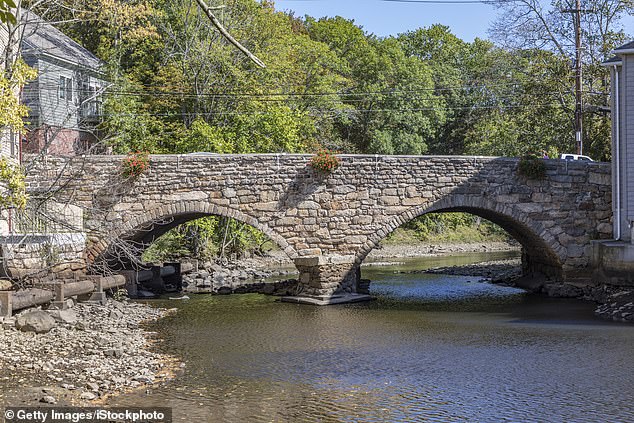 The Old Choate Road Bridge crosses the Ipswich River. The body of water is surrounded on all sides by preserved colonial houses from 300-400 years ago, long before the official founding of America.