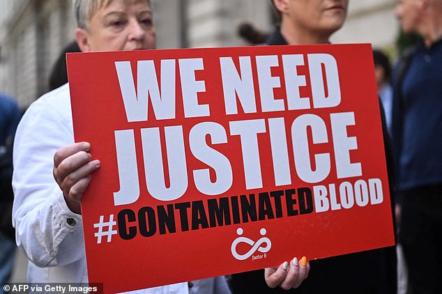 Protesters photographed holding banners at a protest in London in July 2023.