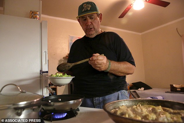 Food stamp recipient Steve Summers prepares dinner in his apartment in Oakland, California.