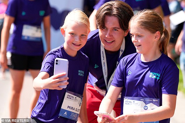 The young prince smiled as he knelt and posed for selfies with the children at today's event.