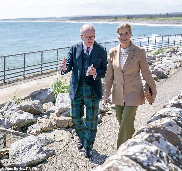 While walking on the beach, Sophie strolled in the sunshine with Lord Lieutenant Patrick Marriott (left)