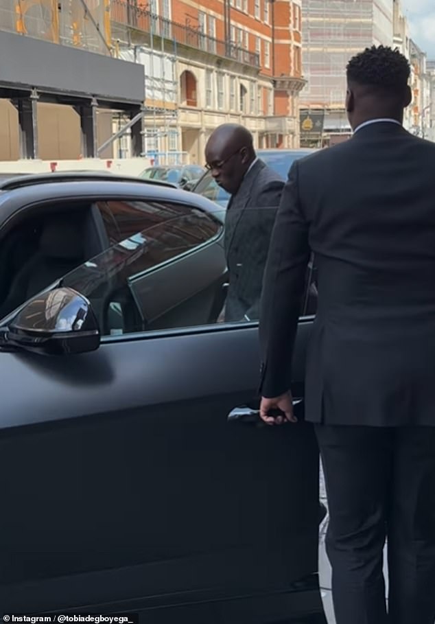 The shepherd is often seen wearing his favorite designers; Louis Vuitton, Gucci and Fendi, and is known for flaunting luxury vehicles from Lamborghini and Porsche (here Pastor Tobi is escorted to a vehicle he is waiting for before the march)