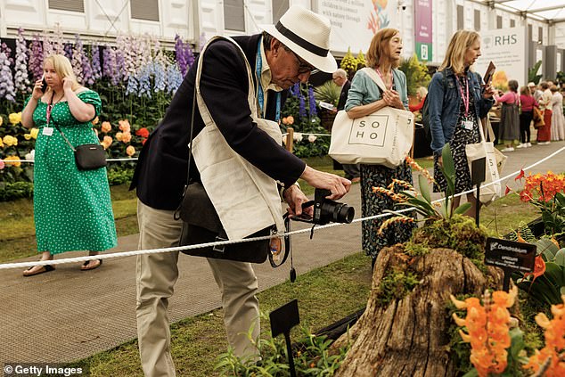 Visitors take photographs on press day at the RHS Chelsea Flower Show at the Royal Hospital Chelsea on May 20, 2024.