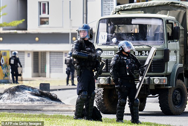 Police and tactical squad officers (pictured) blocked roads in a bid to restore order as violence escalated.