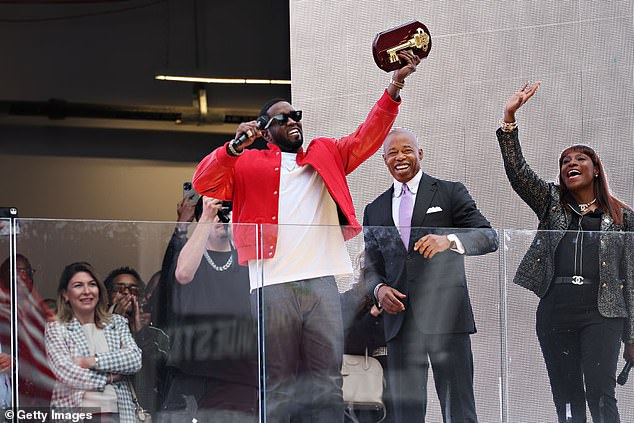 New York Mayor Eric Adams, pictured behind Combs, threatened to take away the key to the city he gave the rapper in September last year.