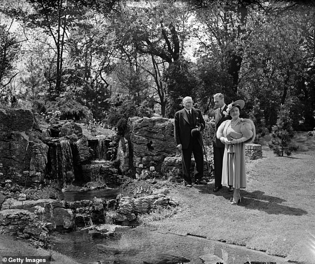 King George VI and Queen Elizabeth, the Queen Mother, speaking to the architect of a miniature waterfall built in one of the display gardens at the Chelsea Flower Show in 1950.