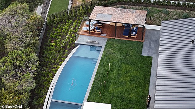 The Batman logo at the bottom of his pool can be seen here in an aerial shot in daylight. Perry's body was found in the hot tub next to the pool, at the bottom of this photo.