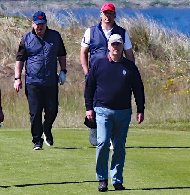 Andrew pictured with two other golfers on the course this morning. The Duke of York could be seen wearing a navy blue jumper with a gray baseball cap.