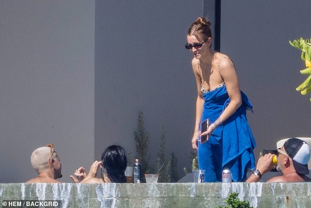 At one point, Ashlee wrapped herself in a blue towel and chatted with her second husband, Evan Ross-Næss (left), while he relaxed in the hot tub.