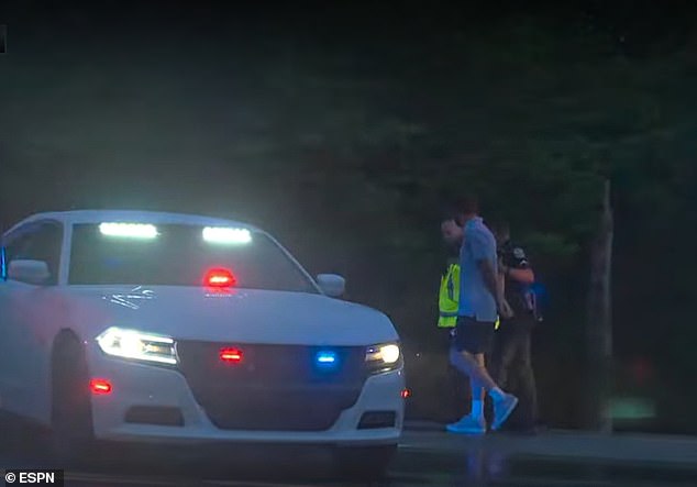 In stunning footage the two-time Masters winner is seen being led to a police car.