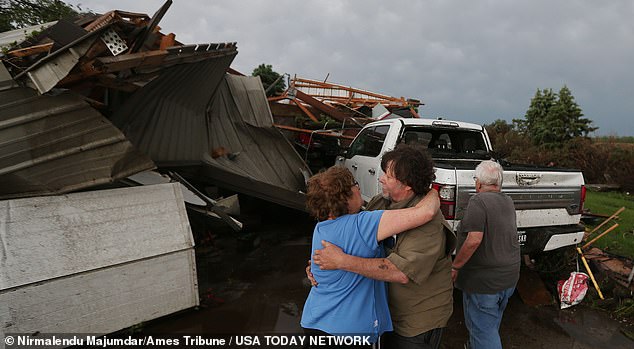 Iowa resident June Handsaker comforts her brother Larry after a tornado destroyed their home Tuesday afternoon in Nevada, Iowa.