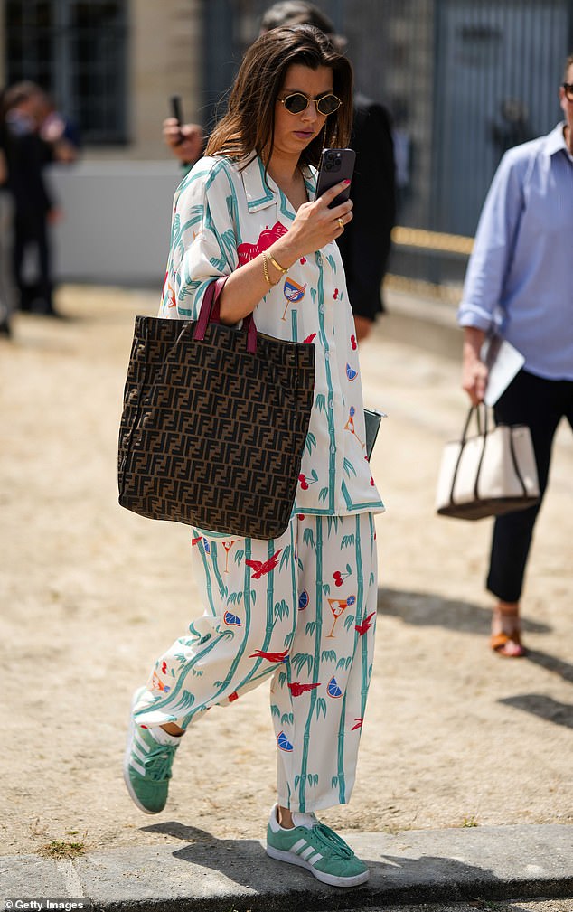 Pictured: A glamorous guest seen wearing green Adidas Gazelles with a printed ensemble at Paris Fashion Week in June 2023.