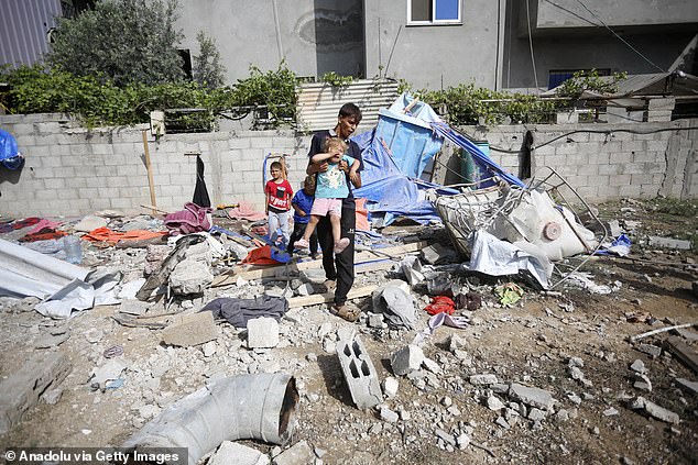 Civil defense teams and civilians conduct search and rescue operations among the destroyed building following the Israeli attack on the Az-Zawayda neighborhood in Deir al-Balah, Gaza, on May 22, 2024.