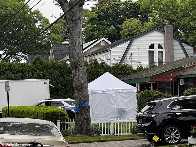 White tents go up outside the Massapequa Park home on First Avenue, with New York State Police officers blocking the street.