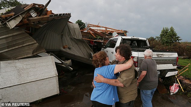 June Handsaker comforts her brother Larry Handsaker after a tornado damaged their home in Nevada, Iowa