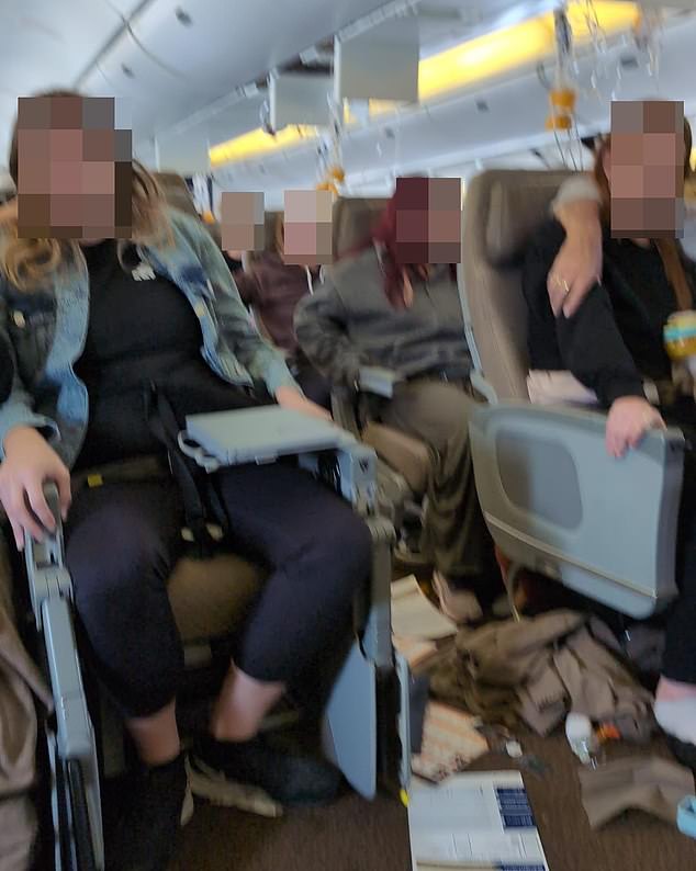 Passengers are seen in the cabin after the incident, with their belongings scattered on the floor and oxygen masks hanging from above.